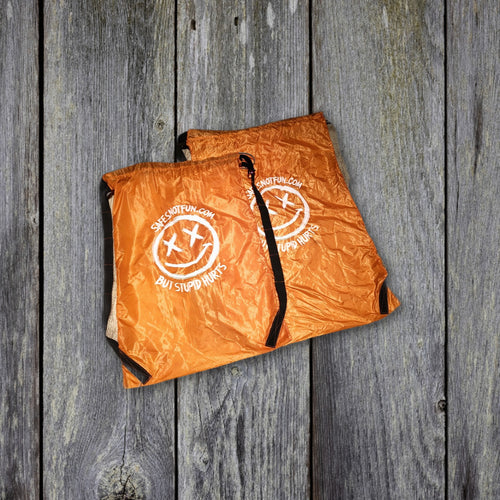 Both drawstring bag sizes on weathered wood boards